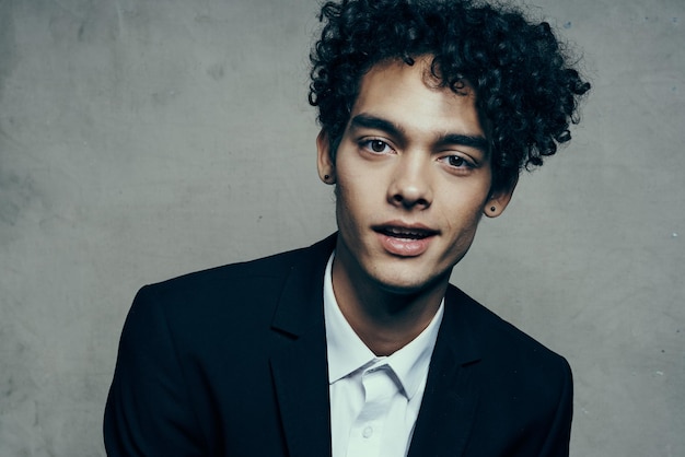 Hombre guapo en traje de cabello rizado emociones modelo de confianza en sí mismo