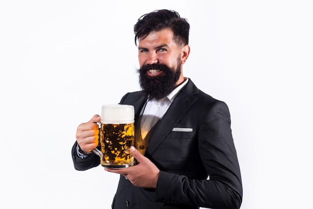 Hombre guapo en traje negro bebiendo cerveza sobre fondo blanco.