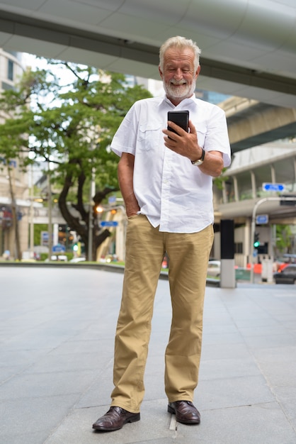Hombre guapo turista senior explorando la ciudad de Bangkok, Tailandia