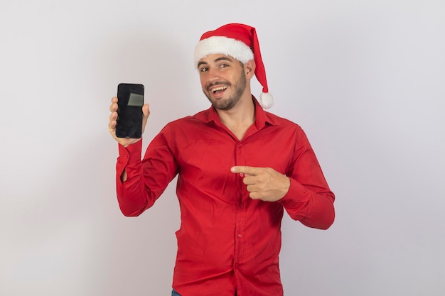 Hombre guapo vestido con traje de navidad sosteniendo un teléfono inteligente con pantalla en blanco para texto