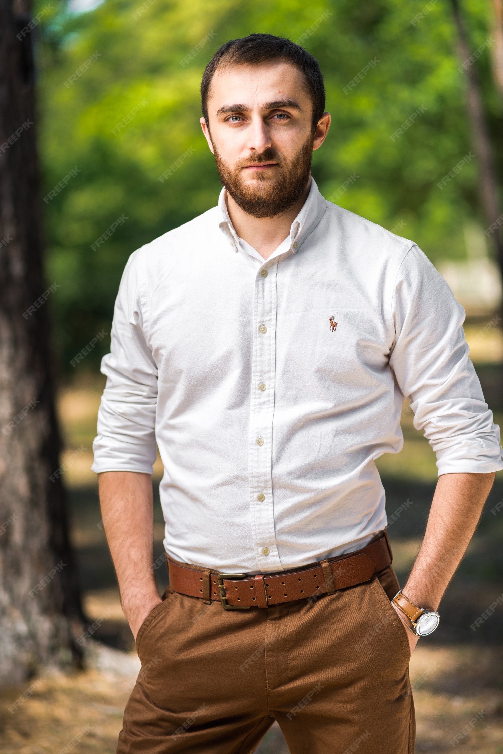 Hombre guapo vistiendo en camisa blanca casual directamente a la cámara | Foto Premium