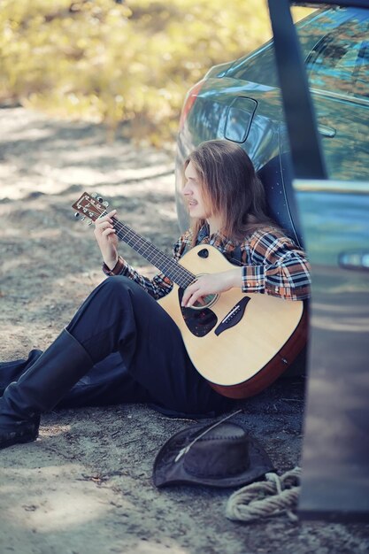 Un hombre con una guitarra en un día de verano al aire libre.