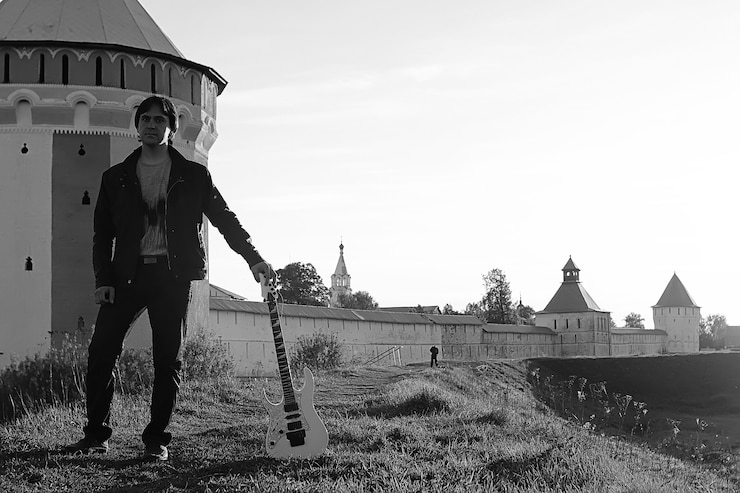 Foto un hombre con una guitarra eléctrica en el paisaje industrial monocromo al aire libre