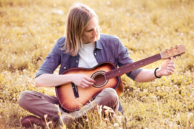 Hombre con guitarra en la naturaleza.