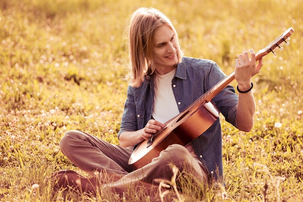 Hombre con guitarra en la naturaleza.