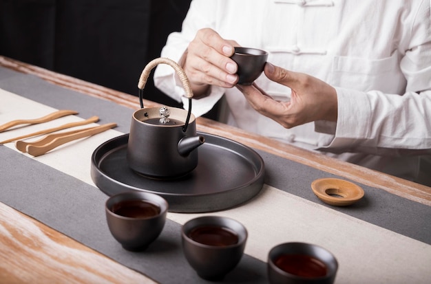 Un hombre con habilidades para preparar té y una cultura de preparación de té hacen posible el equilibrio entre la salud y el bienestar