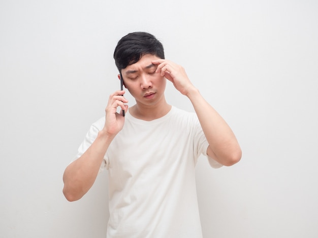 Hombre hablando con celular sintiendo tensión toca su cabeza sobre fondo blanco