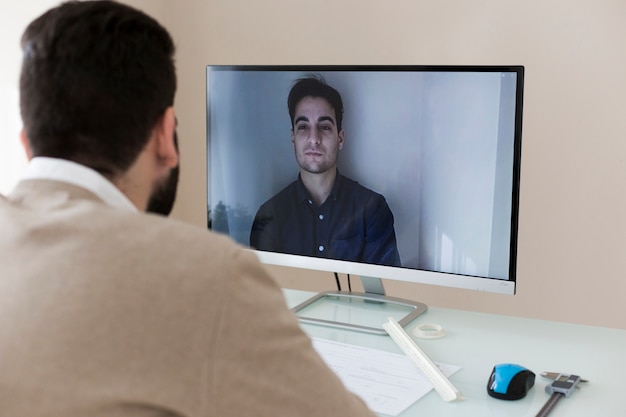 Foto hombre hablando con un compañero por video