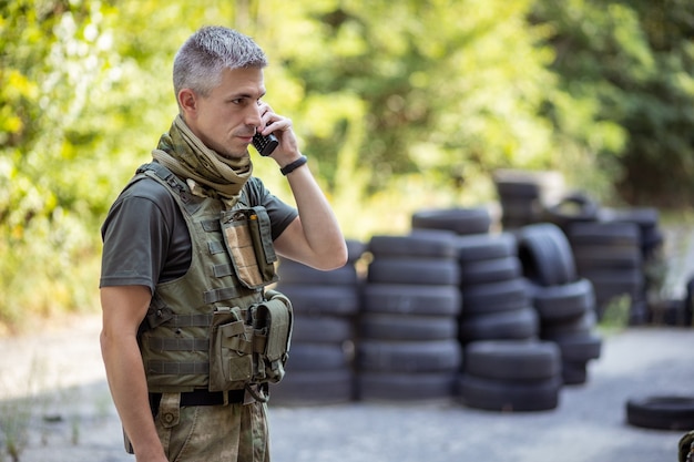 Un hombre hablando por la radio en uniforme militar.