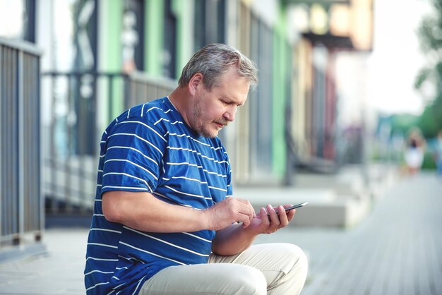 Hombre hablando por teléfono y mirando a los transeúntes en la ciudad, la vista desde atrás