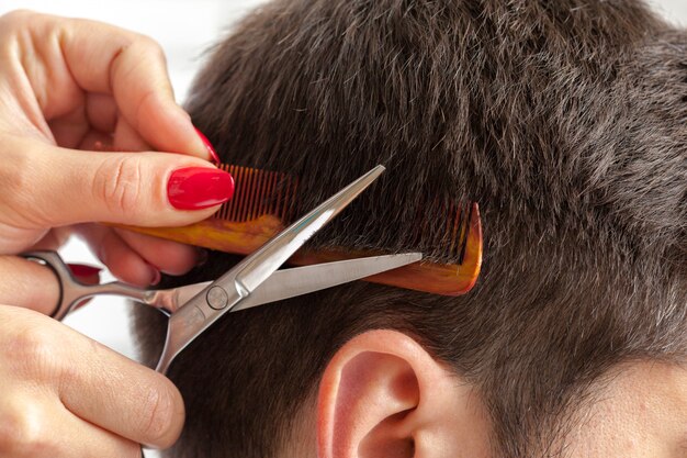 El hombre hace un corte de pelo