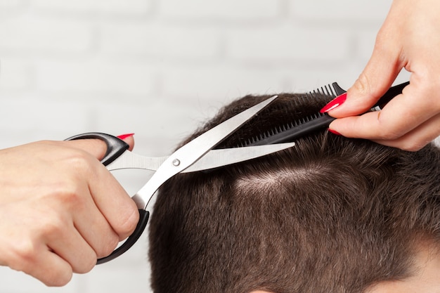 El hombre hace un corte de pelo