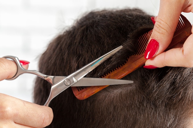 El hombre hace un corte de pelo