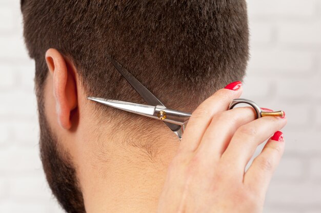 El hombre hace un corte de pelo