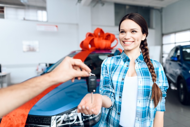 Foto el hombre hace un regalo - carro a su esposa. ella esta sorprendida de esto