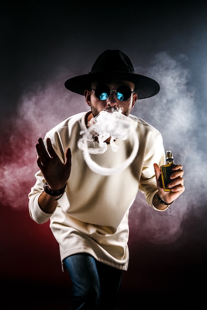 Hombre haciendo anillo de humo con vape