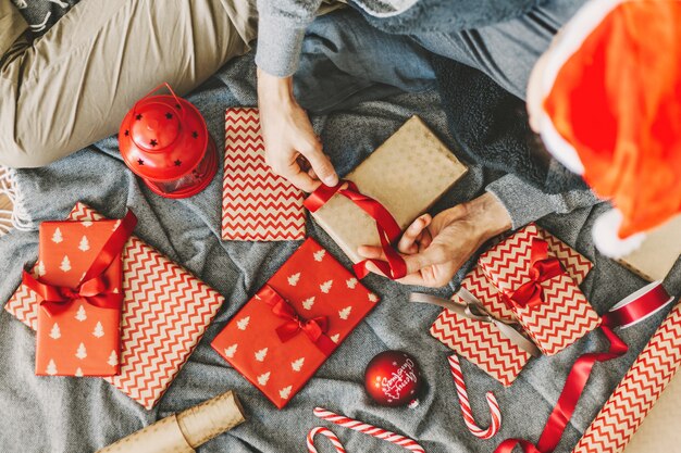 Hombre haciendo arco de cinta en regalo