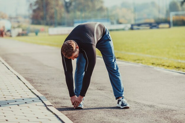 Foto el hombre está haciendo calentamiento antes de ejecutar el entrenamiento. estilo de vida deportivo