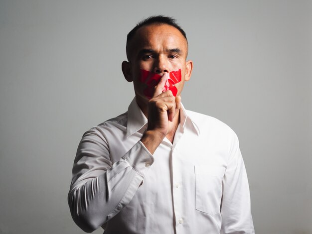 hombre haciendo dedo en los labios gesto de silencio