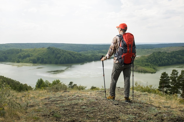 Hombre haciendo ejercicio al aire libre haciendo senderismo utilizando bastones de trekking en el campo en una montaña Travel Lifestyle wanderlust concepto de aventura vacaciones de verano al aire libre