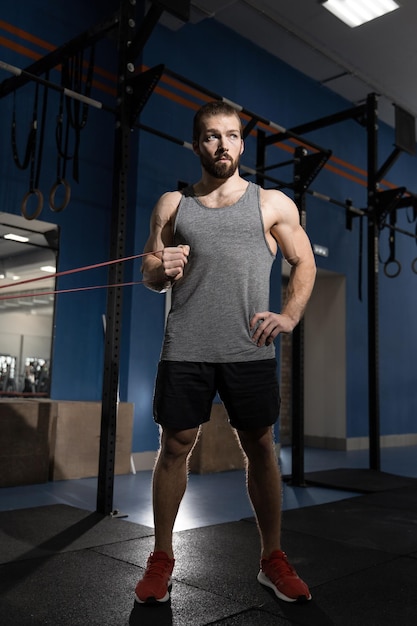 Hombre haciendo ejercicio en el gimnasio con bandas elásticas