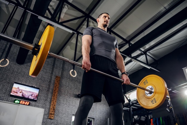 Hombre haciendo ejercicio en un gimnasio con una barra