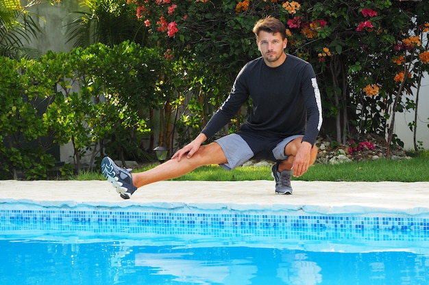 Hombre haciendo ejercicios de estiramiento en la piscina