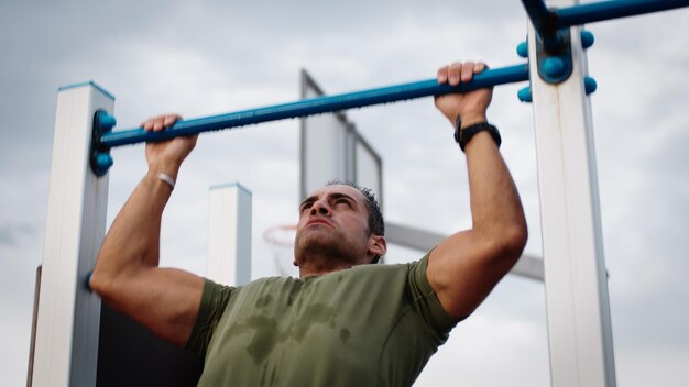 Foto el hombre está haciendo ejercicios de flexión en una barra horizontal