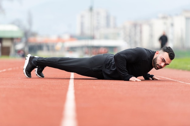 Hombre haciendo flexiones en pista