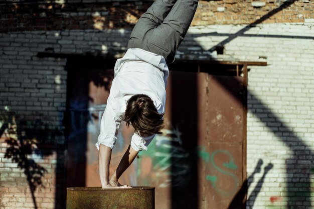 Hombre haciendo un handstand en el tambor durante un día soleado