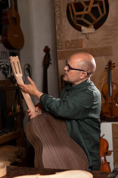 Foto hombre haciendo instrumentos en su taller solo