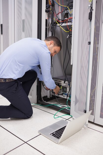 Foto hombre haciendo mantenimiento y fijación de cables en el servidor