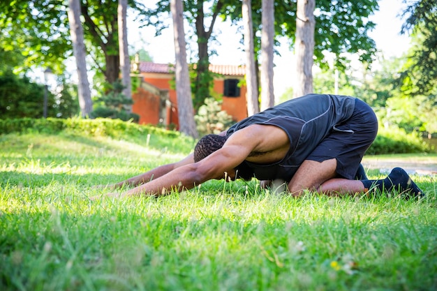 Foto un hombre está haciendo una postura de yoga en un campo cubierto de hierba durante un entrenamiento