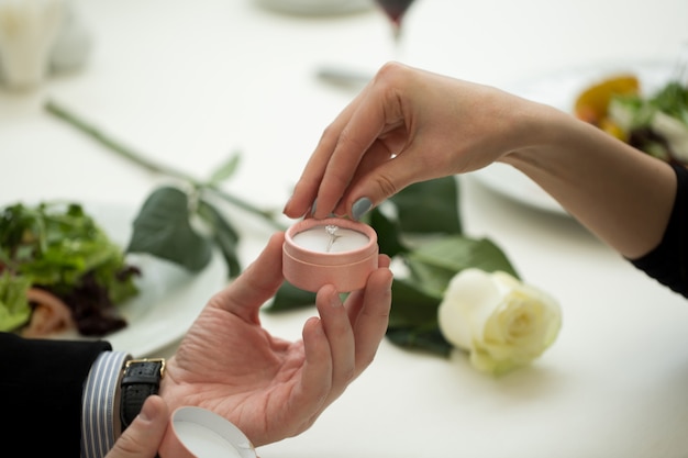 Hombre haciendo propuesta de matrimonio a la novia en el restaurante, primer plano