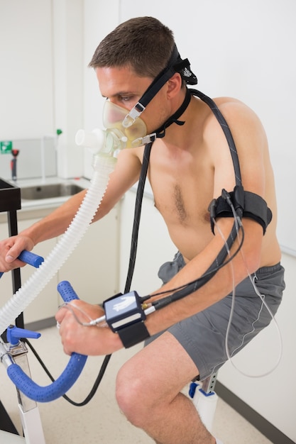 Foto hombre haciendo prueba de aptitud en bicicleta estática