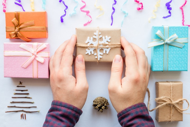 Hombre haciendo regalos de Navidad sobre un fondo blanco.