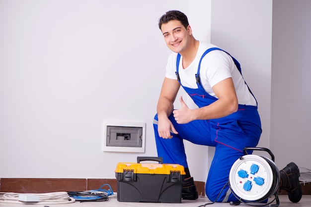 Hombre haciendo reparaciones eléctricas en casa