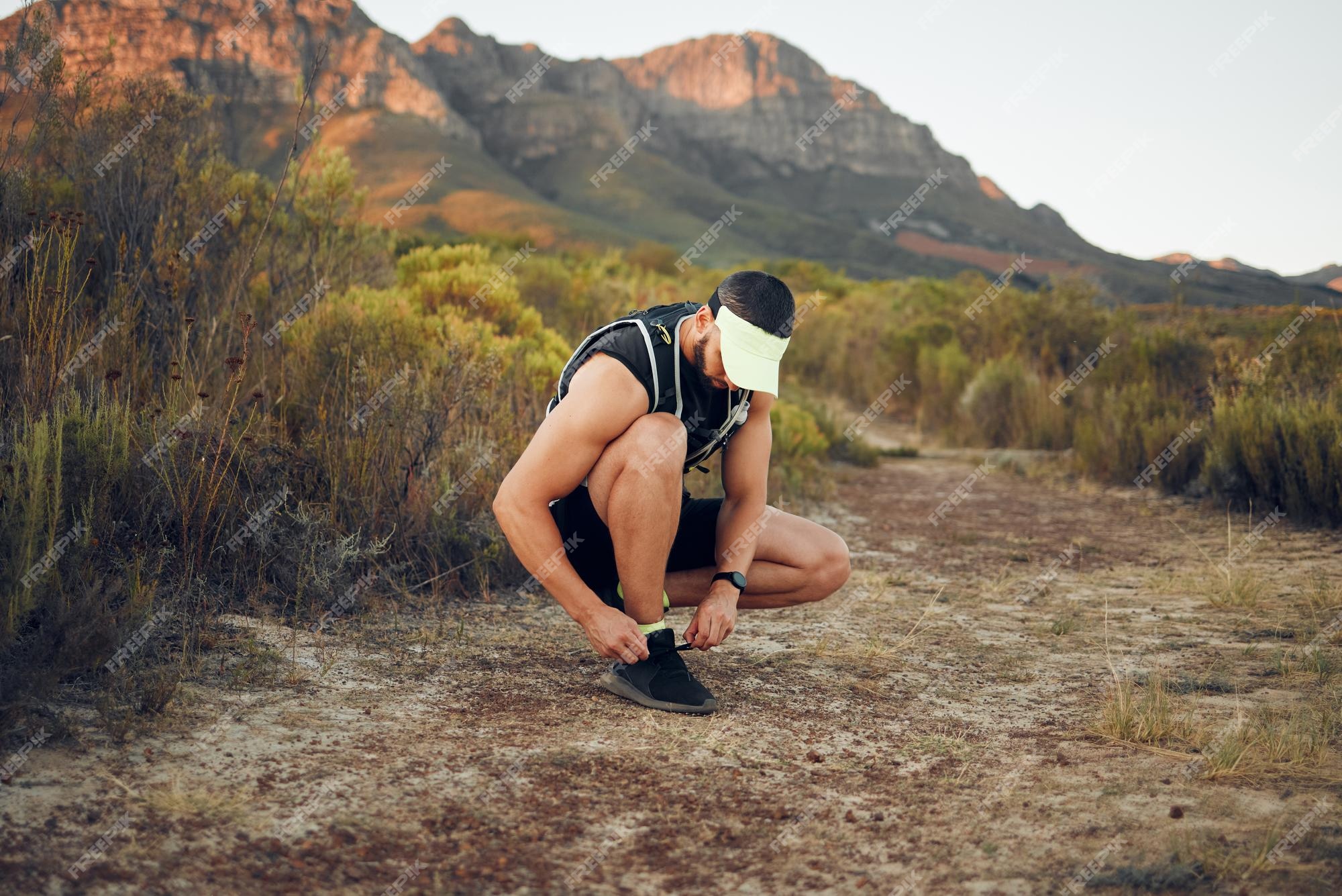 Hombre haciendo senderismo y cordones de zapatos en la montaña para hacer ejercicio, hacer ejercicio y correr zapatillas deportivas entrenamiento masculino deportes y salud en en verano con naturaleza