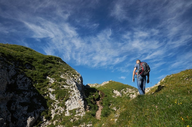 Hombre haciendo senderismo en las montañas con mochila en senderos