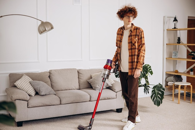 Hombre haciendo trabajo doméstico con aspiradora inalámbrica