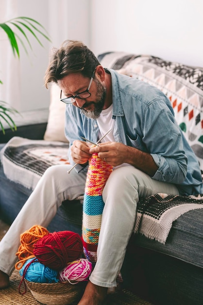 Hombre haciendo trabajo de punto con agujas para relajarse y disfrutar del tiempo interior en casa Terapia de relajación de trabajo hecho a mano Gente haciendo pasatiempos o actividades de ocio de bricolaje solo Concepto de estilo de vida alternativo