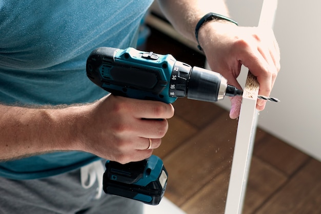 Foto hombre haciendo trabajos de renovación en casa perforando con un destornillador