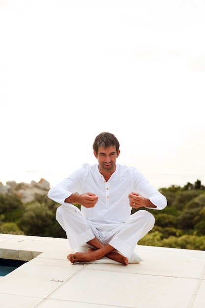 Hombre haciendo yoga en la piscina con espacio de copia