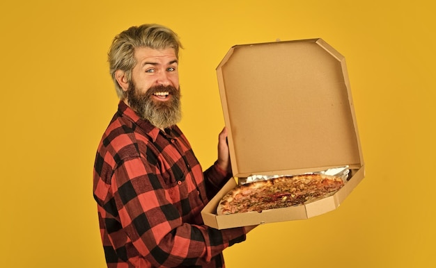 Hombre hambriento va a comer pizza solo Fresco y caliente De humor para la comida italiana Hombre barbudo hipster sostiene una caja de pizza de cartón Servicio de entrega de pizza Enviar comidas a los hogares Entrega de comida al apartamento