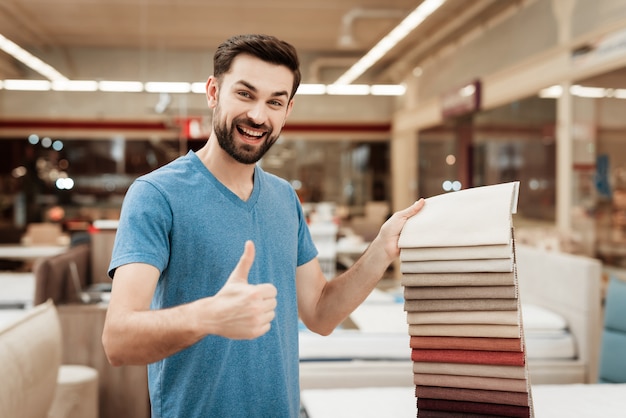 Foto hombre hermoso joven que elige el color del colchón