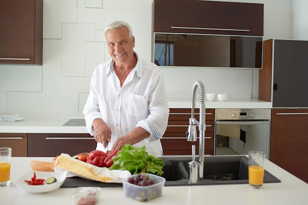 Hombre hermoso que cocina en casa que prepara la ensalada en cocina.