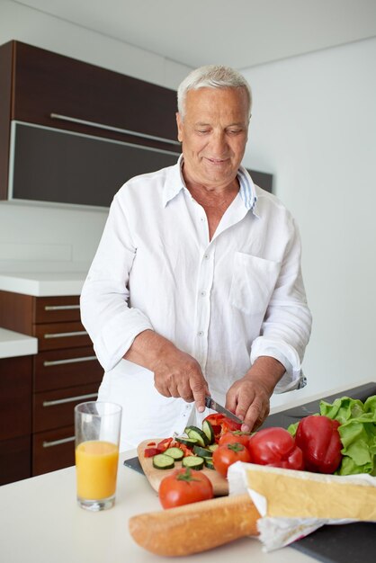 Hombre hermoso que cocina en casa que prepara la ensalada en cocina.