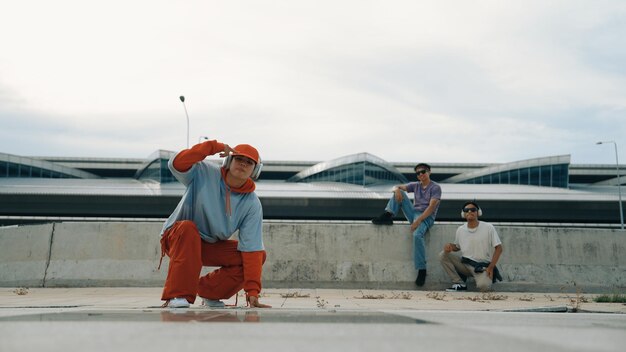 Hombre de hip hop usando auriculares mientras posa ante la cámara con confianza y vivaz