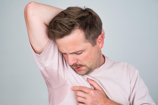 Hombre con hiperhidrosis sudando mucho bajo la axila