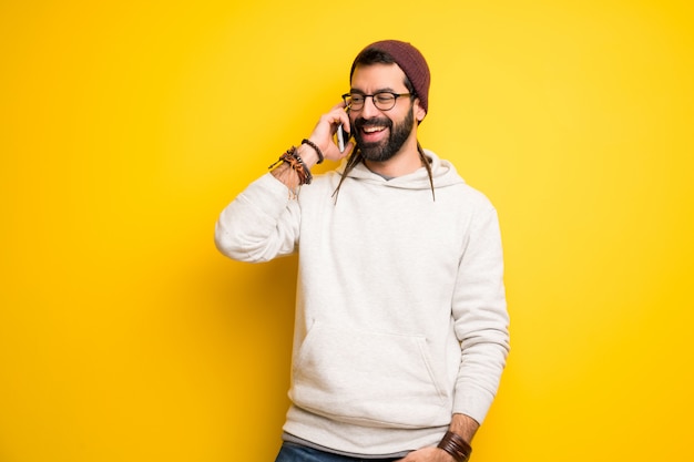 Hombre hippie con rastas manteniendo una conversación con el teléfono móvil